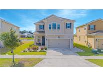 Charming two-story home featuring a two-car garage, manicured lawn, and appealing landscaping at 4432 Seven Canyons Dr, Kissimmee, FL 34746