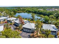 An aerial view of condos overlooking a serene lake surrounded by lush greenery and mature trees at 4465 Ring Neck Rd # C, Orlando, FL 32808