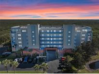 Stunning exterior view of the condo building against a vibrant sunset sky at 5300 S Atlantic Ave # 16-505, New Smyrna Beach, FL 32169
