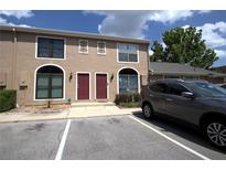 Townhouse exterior featuring two-stories, two front doors, a tan exterior, and nearby parking spaces at 613 Casa Park Court B N Ct # B, Winter Springs, FL 32708