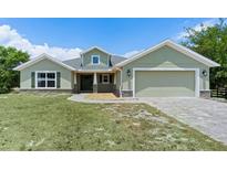 Charming one-story home with a well-manicured lawn, two-car garage, and inviting entryway at 7017 Bridle Path, St Cloud, FL 34771