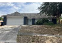 Cozy single-story home with a white garage door, dark siding accents, and a spacious front yard at 7614 Brisbane Ct, Orlando, FL 32835