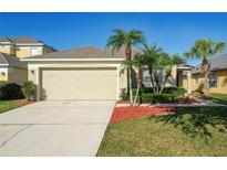 Charming home featuring a two-car garage, manicured lawn, and tasteful landscaping at 1175 Seasons Blvd, Kissimmee, FL 34746