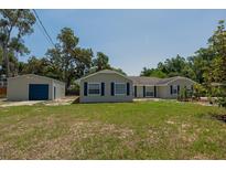 Charming single-story home with a detached garage and a well-maintained lawn at 131 Lake Charles Rd, Deland, FL 32724