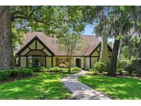 Charming home with well-manicured lawn and pathway leading to the front door, shaded by mature trees at 1742 Barcelona Way, Winter Park, FL 32789