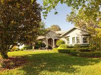 Charming single-story home with a lush green lawn and mature trees in a desirable neighborhood at 1802 Hartford Path, The Villages, FL 32162