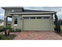 A beautiful home featuring a spacious garage and a meticulously designed brick driveway at 3144 Songbird Cir, Harmony, FL 34773