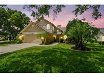 Charming two-story home featuring a well-maintained lawn, mature trees, and inviting curb appeal at sunset at 383 Brushwood Ln, Winter Springs, FL 32708