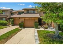 Charming townhome featuring a well-maintained front yard, brick accents, and attached one-car garage at 3928 Villas Green Cir, Longwood, FL 32779