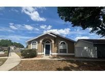 Inviting single-story home with a blue door and arched windows, set under a bright blue sky at 410 Horizon Dr, Winter Springs, FL 32708