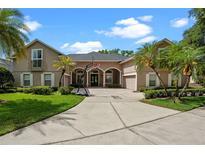 Beautiful single-story home featuring a spacious driveway, lush landscaping, and classic architectural details at 5108 Sailwind Cir, Orlando, FL 32810