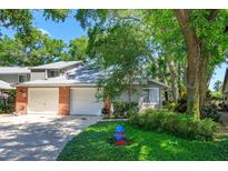 Charming home with two-car garage, brick accents, mature trees, and a well-maintained lawn with a fire hydrant at 617 Red Oak Cir # 121, Altamonte Springs, FL 32701
