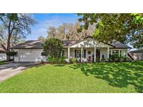 Charming single story home featuring a well manicured lawn, inviting front porch and attached garage at 819 E Harbour Ct, Ocoee, FL 34761