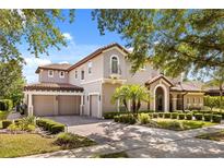 Stately home showcases a three-car garage and manicured landscaping, creating a welcoming curb appeal at 9032 Tavolini Ter, Windermere, FL 34786