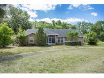Charming single-story brick home with a well-maintained lawn and mature trees at 1130 Woodchuck Ct, Orange City, FL 32763