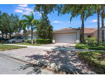 Charming single-story home featuring a brick driveway, two-car garage, and well-manicured landscaping with mature trees at 11908 Fiore Dr # 1, Orlando, FL 32827