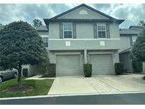 Charming townhome with attached garages, complemented by a well-manicured lawn and mature landscaping at 135 Heritage Park St, Winter Springs, FL 32708