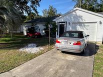 Charming home featuring a well-maintained lawn and convenient driveway parking and golf cart at 1707 E Schwartz Blvd, Lady Lake, FL 32159