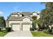 Charming two-story home featuring a two-car garage, a well-manicured lawn, and a welcoming light blue front door at 2624 Daulby St, Kissimmee, FL 34747