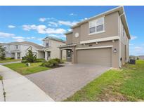 Charming two-story home featuring a two-car garage, neutral stucco exterior, and a neatly paved driveway at 2932 Muller Oak Loop, Ocoee, FL 34761