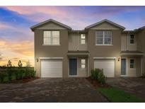 Charming townhome exterior with attached garages and manicured landscaping at 2971 Brie Hammock Bnd, St Cloud, FL 34773