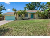 Charming single-story home with a well-maintained lawn and a lovely teal-colored garage door at 3606 Palm Ave, Apopka, FL 32703