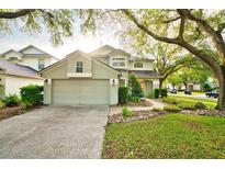 Two-story home featuring a well-manicured lawn, rock garden, and a convenient two-car garage at 4448 Riverton Dr, Orlando, FL 32817