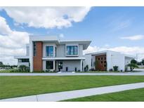 Modern home showcasing clean lines, sleek design, and a well-manicured lawn on a sunny day at 5023 Sawyer Cove Way, Windermere, FL 34786