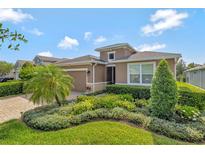 Inviting home exterior with a lush, landscaped front yard and a paver driveway at 553 Adenmore Ter, Deland, FL 32724