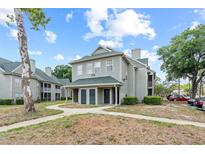 Inviting two-story condo showcasing a walkway, manicured landscaping, and convenient parking at 6100 Westgate Dr # 101, Orlando, FL 32835