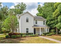 Charming two-story home featuring a landscaped front yard and inviting front porch at 101 W Oakland Ave, Oakland, FL 34760