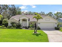Charming one-story home featuring a well-manicured lawn and a two-car garage at 1024 Destin Dr, Lake Wales, FL 33898