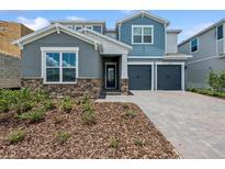 Charming two-story home featuring stone accents, a two-car garage, and a beautifully landscaped front yard at 13123 Faro Ct # 23, Winter Garden, FL 34787