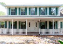 Charming two-story home featuring a welcoming front porch and classic white siding with green shutters at 2320 Red Ember Rd, Oviedo, FL 32765