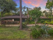 Beautiful brick home featuring lush landscaping, mature trees, and an inviting entrance at sunset at 2350 Worthington Rd, Maitland, FL 32751