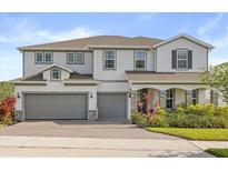 Beautiful two-story home featuring a three car garage and manicured landscaping at 2431 Knoll Dr, Apopka, FL 32712