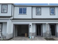 Exterior view of townhome featuring a one-car garage and covered entry at 5113 Prairie Preserve Run, St Cloud, FL 34772
