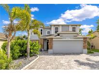 Beautiful two-story home featuring a well-manicured front yard, paved driveway and attractive architectural details at 10142 Hidden Dunes Ln, Orlando, FL 32832