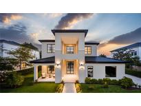 Striking modern two-story home with black-trimmed windows and manicured landscaping at sunset at 11303 Windermere Rd, Windermere, FL 34786