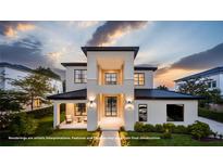 Modern two-story home boasts a clean design, well-manicured lawn, and elegant black framed windows at 11303 Windermere Rd, Windermere, FL 34786