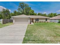 Charming single-story home with a well-maintained lawn and a two-car garage at 131 Pecan Pass, Ocala, FL 34472