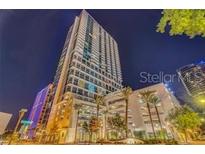 Stunning high-rise building with manicured landscaping and vibrant city surroundings under the bright evening sky at 150 E Robinson St # 2002, Orlando, FL 32801