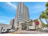 Modern high rise building with a glass facade and a parking garage in an urban setting at 150 E Robinson St # 2002, Orlando, FL 32801