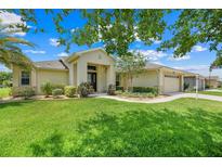 Well-maintained single-story home with a manicured lawn and beautiful landscaping at 27401 Pine Straw Rd, Leesburg, FL 34748