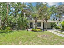 Charming single-story home with lush landscaping, mature trees, and a convenient carport at 318 E Jersey St, Orlando, FL 32806