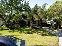 Charming single-story home with mature trees, a lush lawn, and a driveway in a quiet neighborhood at 318 E Jersey St, Orlando, FL 32806