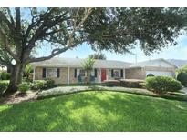 Charming brick home featuring a well-manicured lawn and mature tree providing ample shade at 4141 Fallwood Cir, Orlando, FL 32812