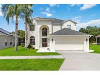 Elegant two-story home with a well-manicured lawn, lush landscaping, and a spacious two-car garage at 4751 Aguila Pl, Orlando, FL 32826