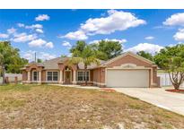 Charming single-story home with a two-car garage, lush landscaping, and a well-manicured lawn at 514 Richmond Ave, Deltona, FL 32725