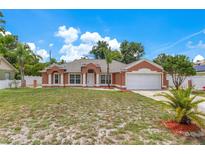 Charming single-story home featuring a well-manicured lawn and two-car garage at 514 Richmond Ave, Deltona, FL 32725